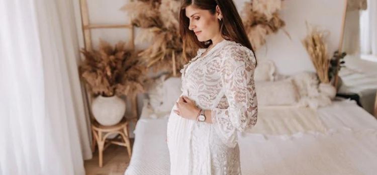 Lady pose in her bedroom wearing a beautiful maternity dress