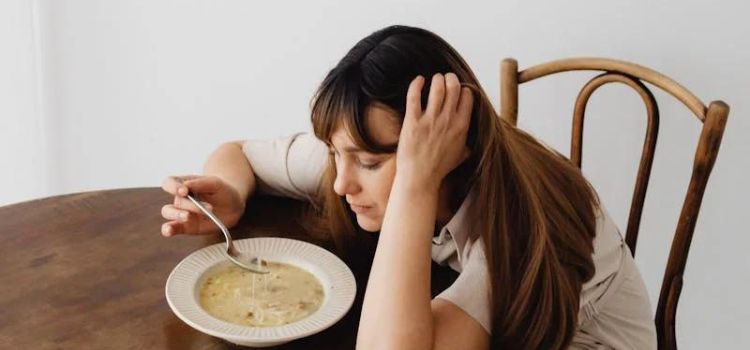 Pregnant woman enjoying a bowl of soup, considering the health benefits and risks of clam chowder during pregnancy