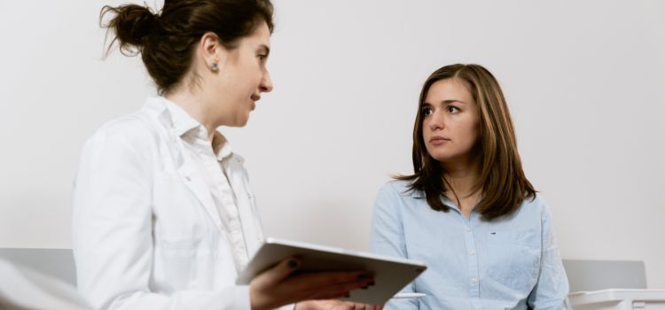 Woman consulting with a doctor about fertility treatment, discussing how Clomid may affect pregnancy test timing